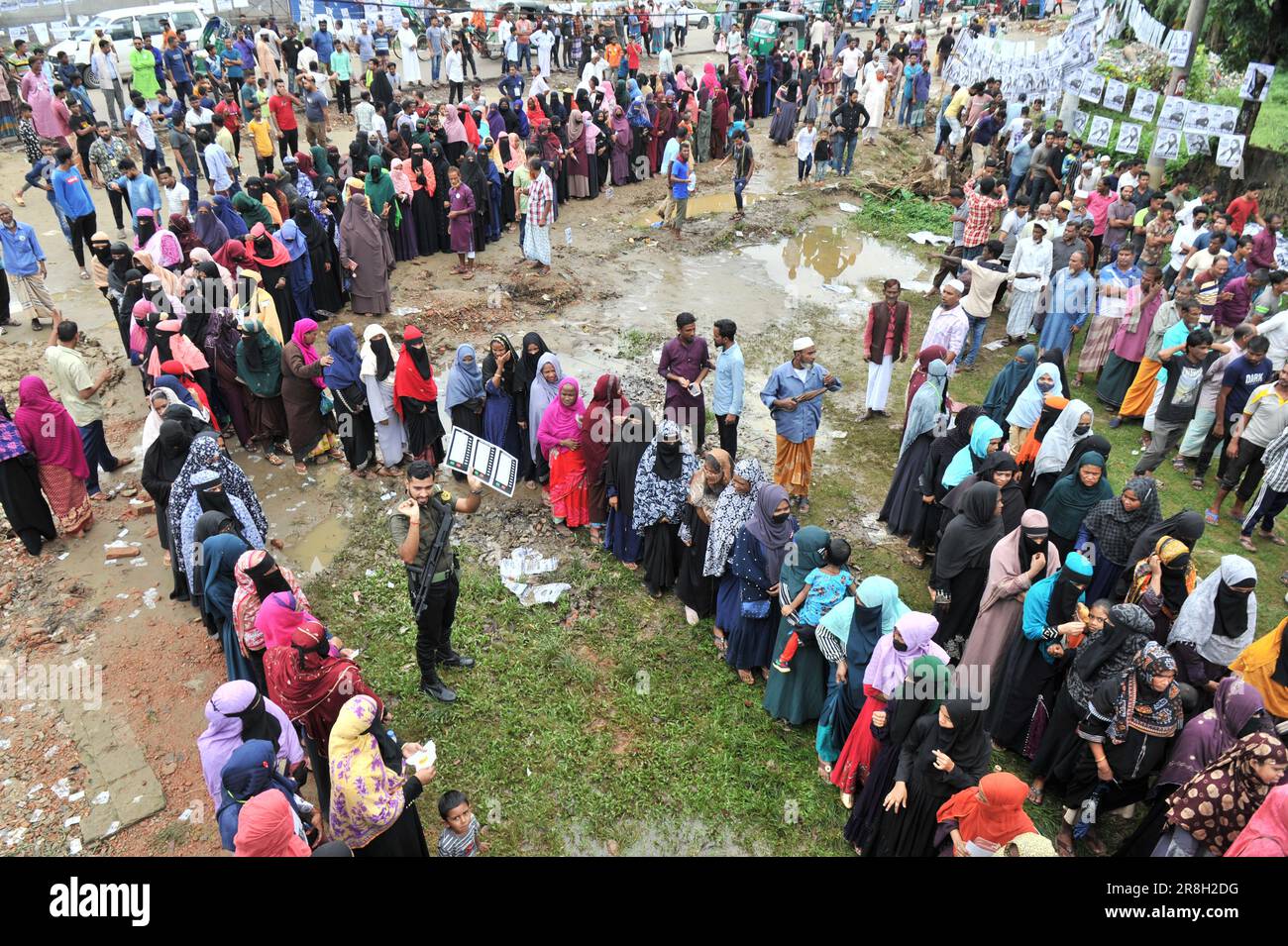 Sylhet, Bangladesh. 21st juin 2023. Des milliers d'électeurs sont venus au bureau de vote de Rashidiya Dakhil Madrasa, numéro 38, qui a été récemment ajouté à Sylhet City Corporation. Les gens ont fait un coup de pied spontané dans les bureaux de vote, mais la lenteur des EVM les a déçus. Pendant ce temps, les membres d'Ansar sont debout et montrent comment voter aux machines EVM. Banque D'Images