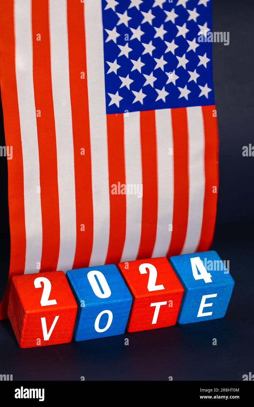 USA Election 2024, vote de l'élection présidentielle américaine, concept, blocs de bois dans les couleurs nationales américaines, l'année et le texte vote, le fond du drapeau américain, vertic Banque D'Images