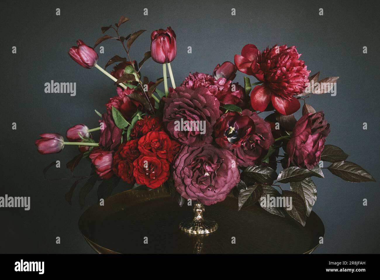 Arrangements floraux de style vintage avec fleurs rouges et violettes Banque D'Images