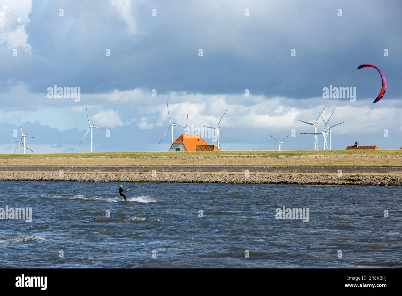 Un kite surfeur passe les vagues près du port de Dagebüll. Le district de Dagebüll Hafen (port de Dagebüll) est situé directement sur les rives de la mer des Wadden. Le port assure des liaisons régulières en ferry vers les charmantes îles de Foehr et d'Amrum. Banque D'Images