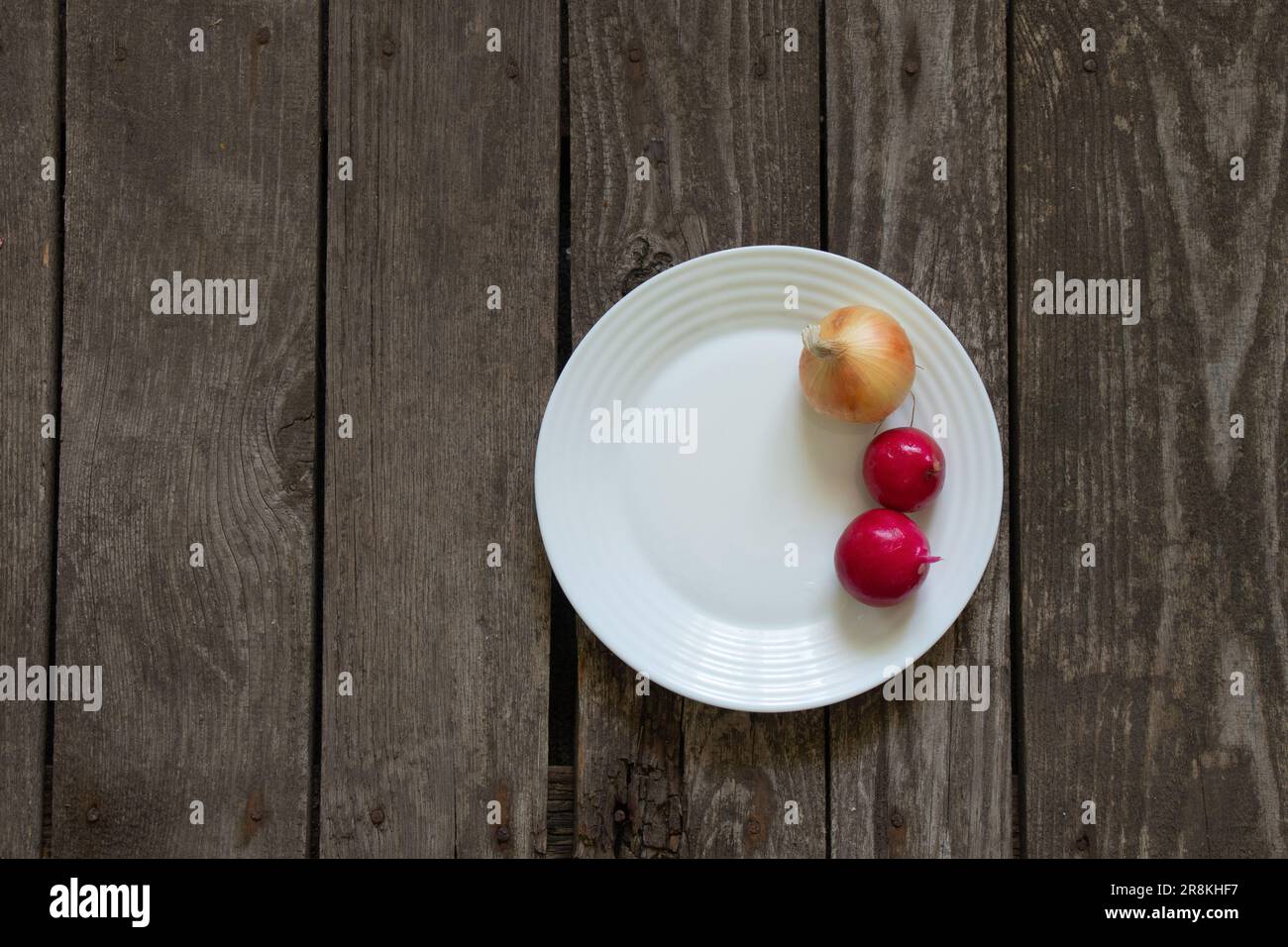 le radis à l'oignon se trouve sur une assiette sur une table en bois Banque D'Images