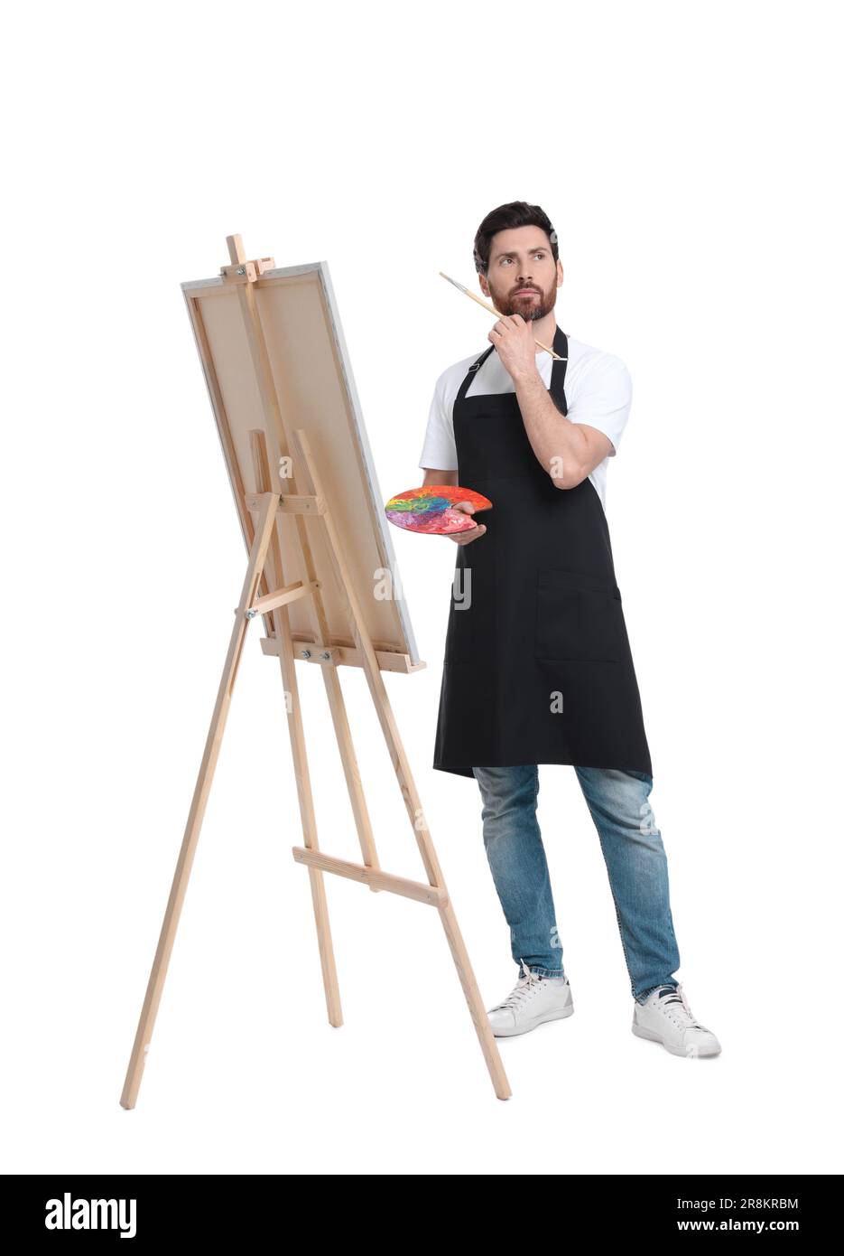 Artiste avec pinceau sur fond blanc. Utilisation du chevalet pour tenir la toile Banque D'Images