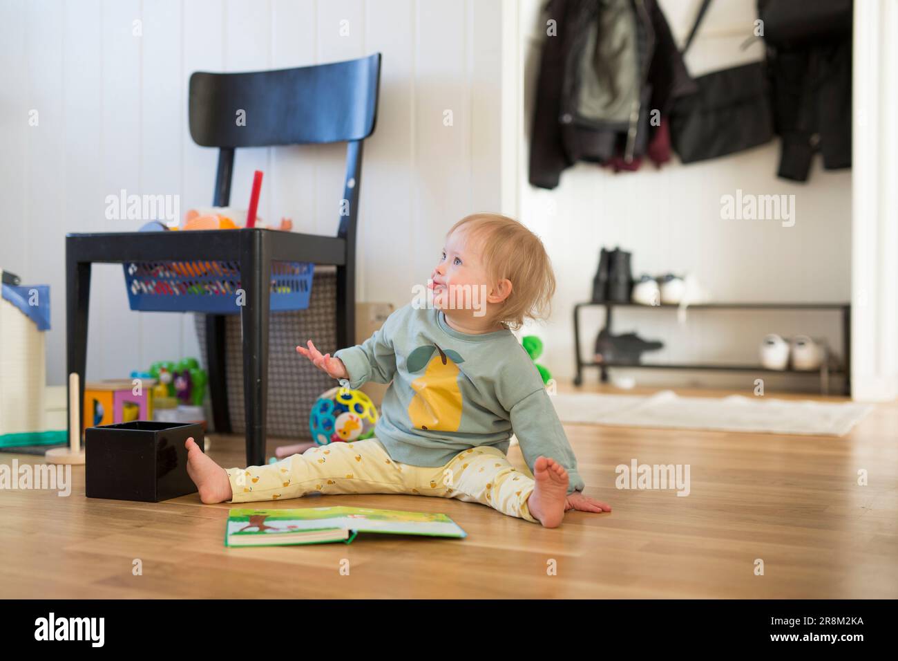 Tout-petit avec le syndrome de Down qui regarde loin Banque D'Images