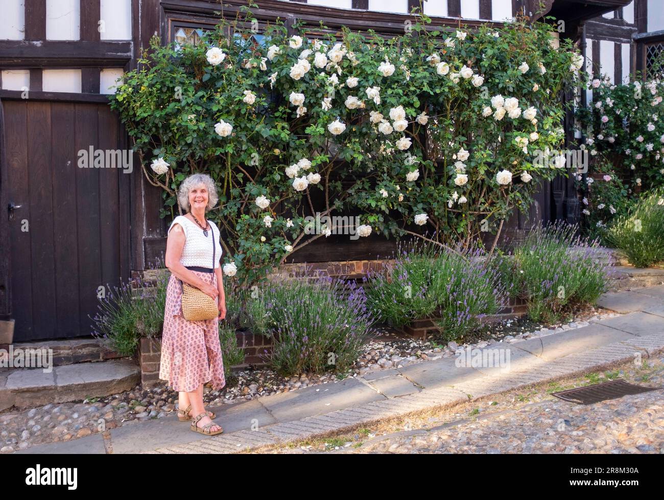 Seigle East Sussex , Angleterre UK - la femme pose par de belles roses à l'extérieur de la propriété dans le centre-ville Banque D'Images