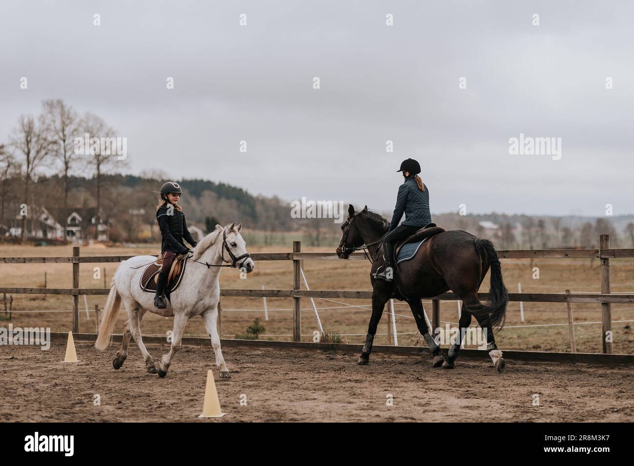 Vue sur l'équitation pour filles sur le paddock Banque D'Images