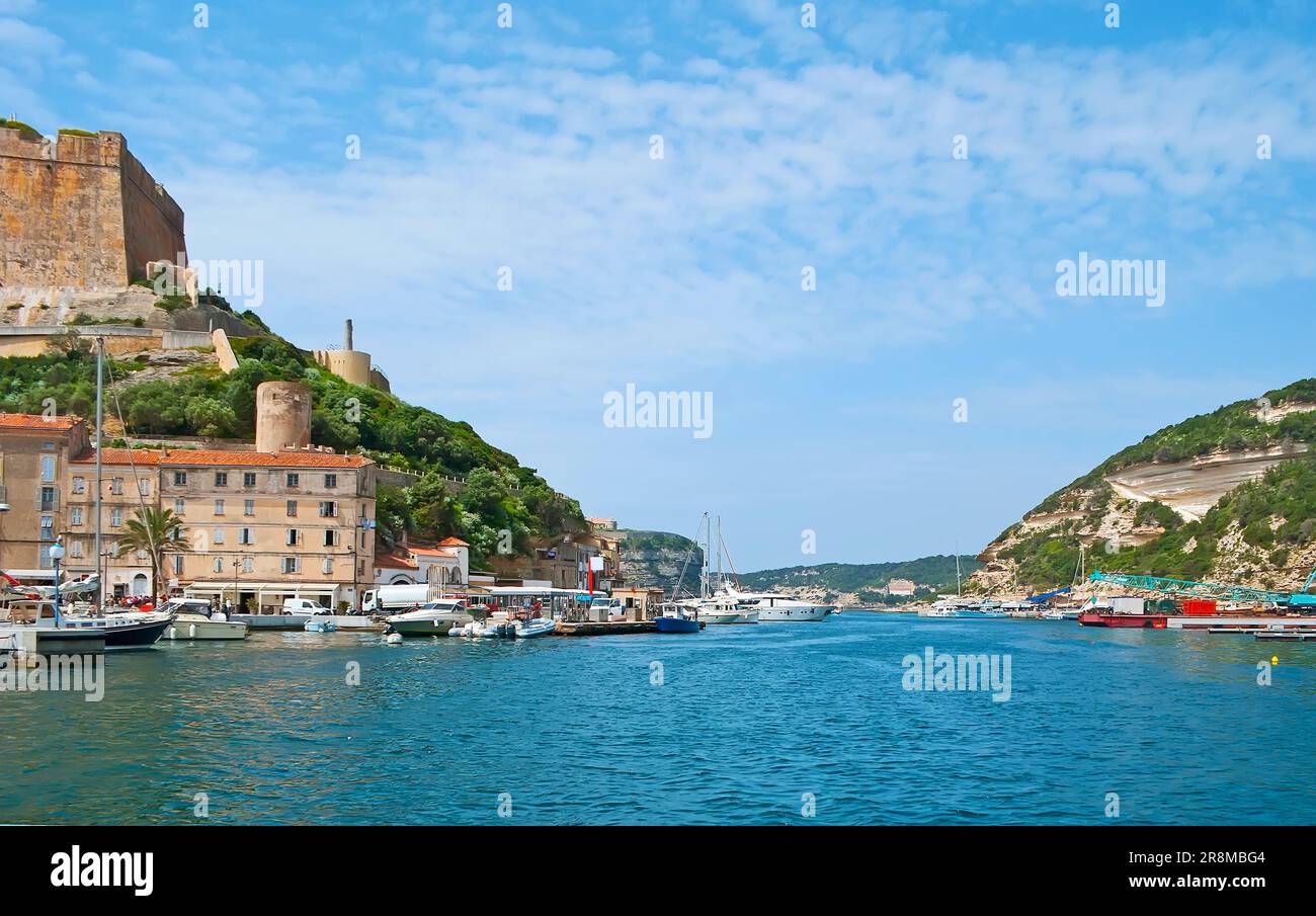 Le voyage le long du port étroit et sinueux de Bonifacio, entouré d'immenses falaises calcaires et de bâtiments historiques de la vieille ville, Corse, France Banque D'Images
