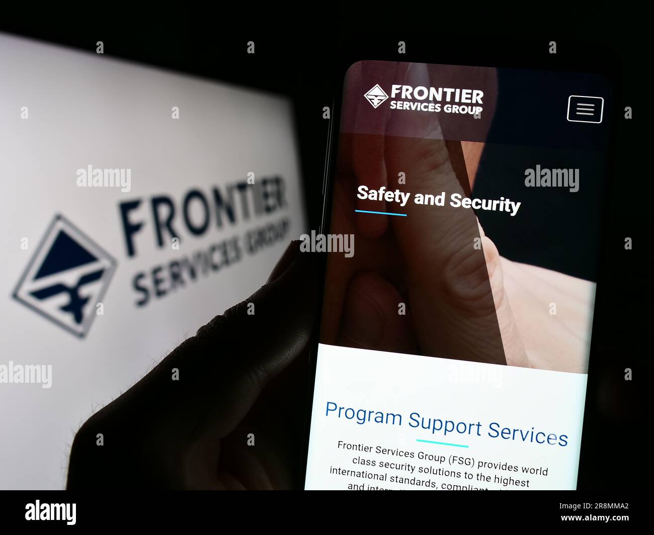 Personne détenant un smartphone avec le site Web de la société Frontier Services Group Limited (FSG) à l'écran avec logo. Concentrez-vous sur le centre de l'écran du téléphone. Banque D'Images