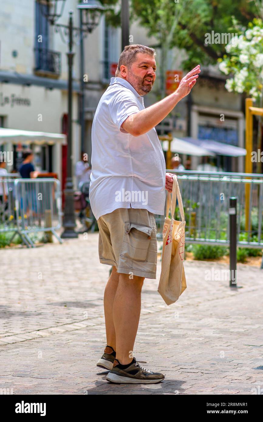 Homme en surpoids, non rasé, en short, agité entre amis - Tours, Indre-et-Loire (37), France. Banque D'Images