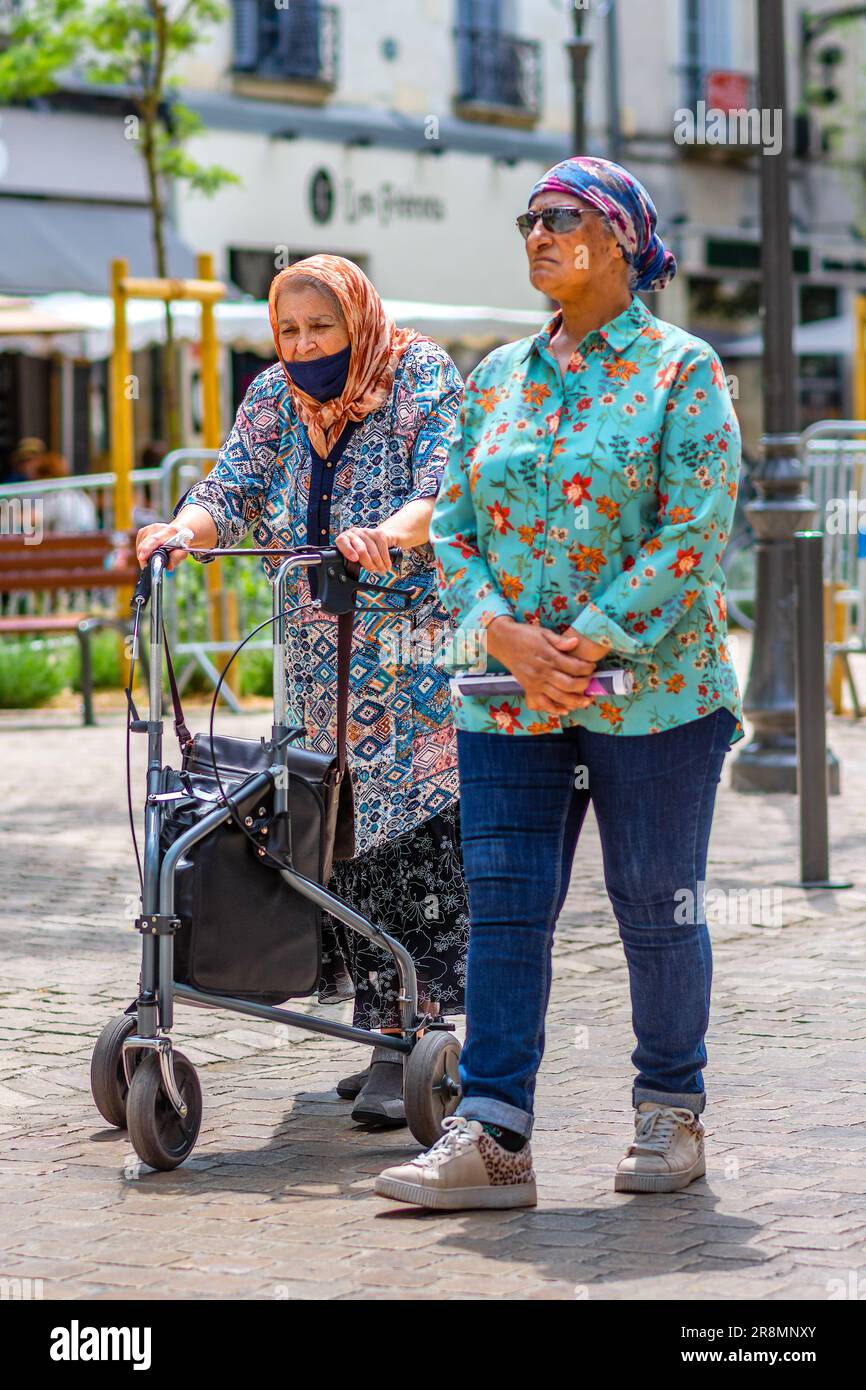 Deux femmes matures vêtues de façon décontractée, dont une avec cadre de marche à roulettes, en centre-ville - Tours, Indre-et-Loire (37), France. Banque D'Images