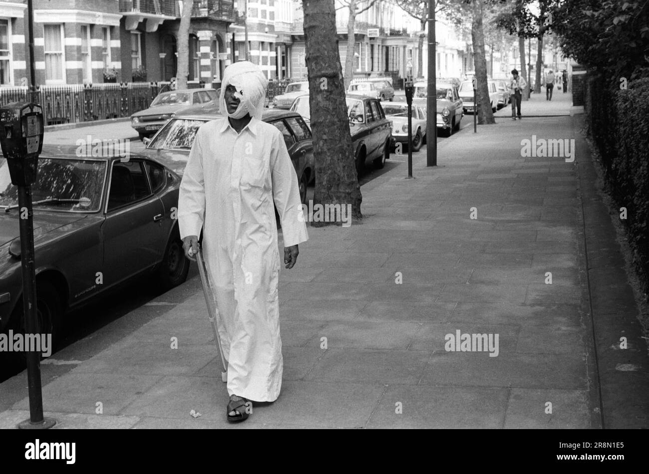 Pauvre Arab Man à Londres en marchant dans la rue d'Earls court. Il a eu des soins médicaux 1970s UK . Les habitants du Moyen-Orient sont venus en Grande-Bretagne pour des soins de santé subventionnés dans les cliniques de Harley Street. Ils ont principalement séjourné dans des hôtels bon marché à Earls court. Earls court, Londres, Angleterre vers 1977 70s UK HOMER SYKES Banque D'Images