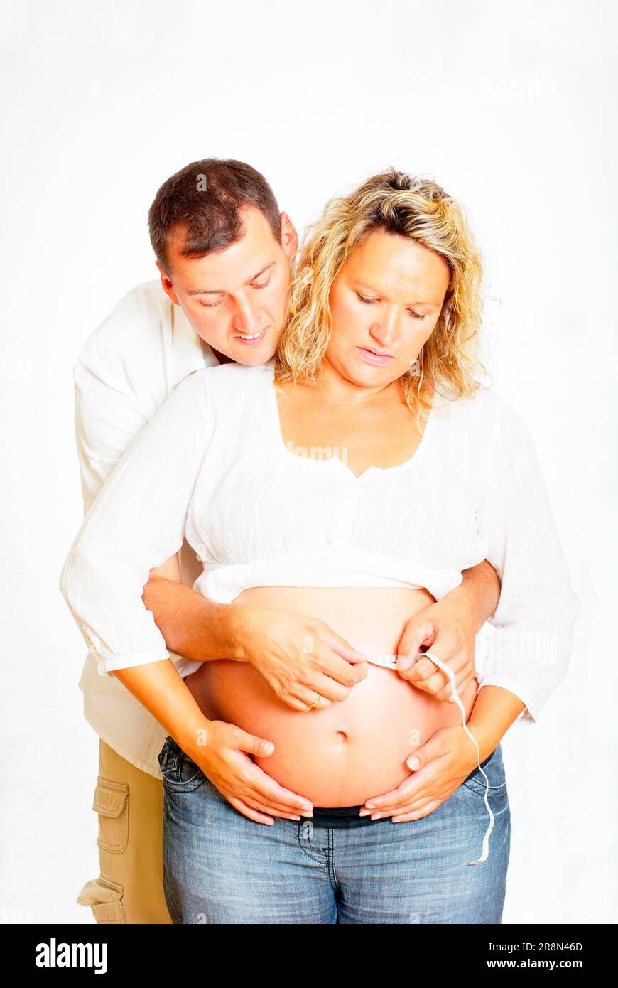 Le mari mesure le ventre de la femme enceinte, mètre ruban, mesure, mesure, circonférence, circonférence du ventre, prendre la mesure, mesurer à nouveau Banque D'Images