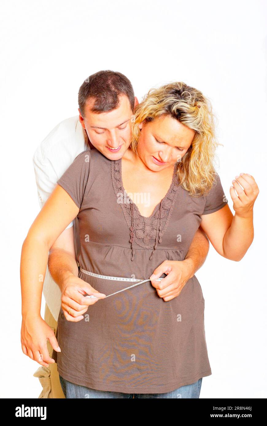 Le mari mesure le ventre de la femme enceinte, mètre ruban, mesure, mesure, circonférence, circonférence du ventre, prendre la mesure, mesurer à nouveau Banque D'Images
