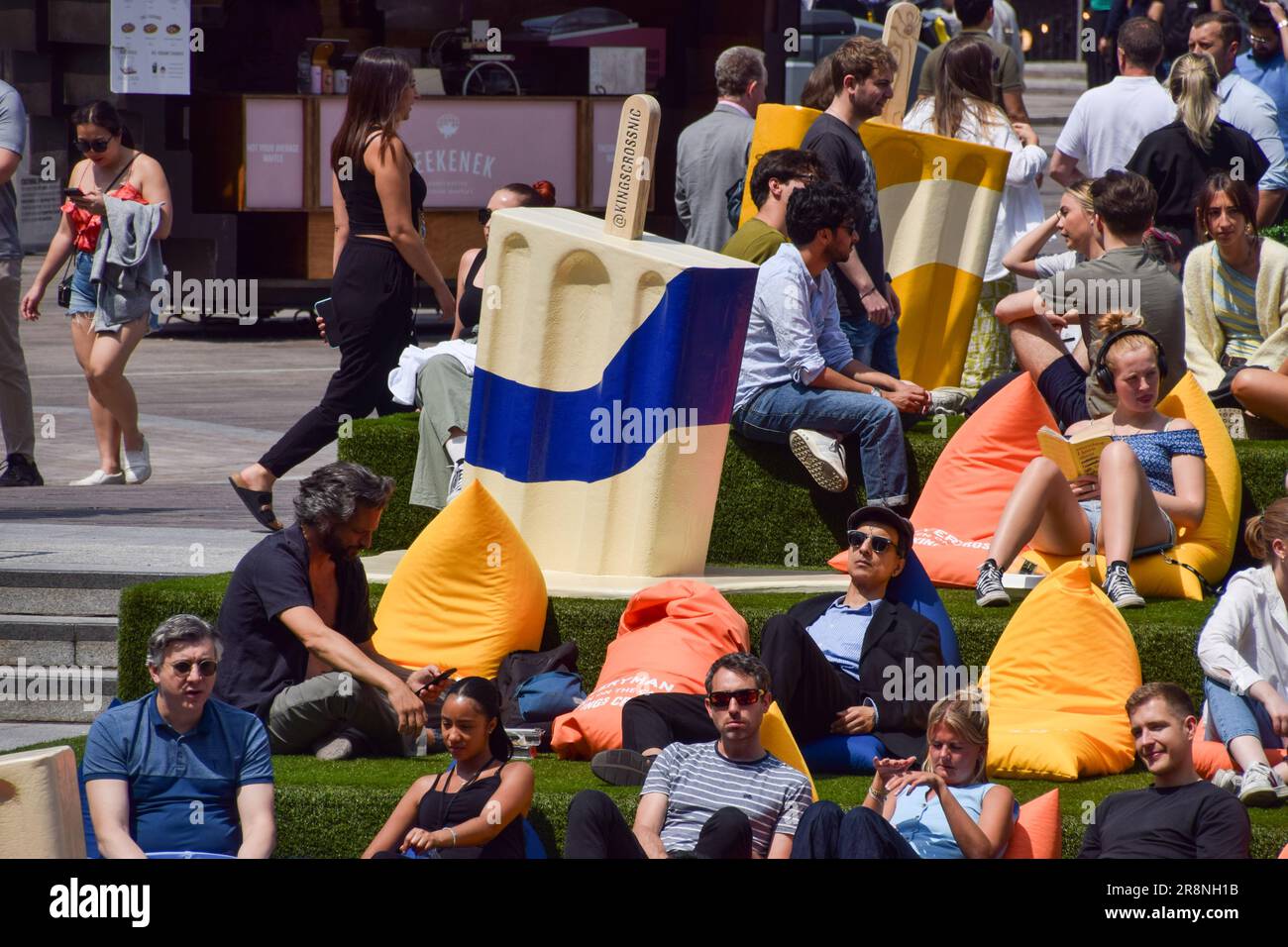 Londres, Angleterre, Royaume-Uni. 22nd juin 2023. La foule prend le soleil à côté de gigantesques « limes de glace géantes » sur l'herbe artificielle de Granary Square, la Croix du roi, alors que les températures montent en flèche dans la capitale. (Credit image: © Vuk Valcic/ZUMA Press Wire) USAGE ÉDITORIAL SEULEMENT! Non destiné À un usage commercial ! Banque D'Images
