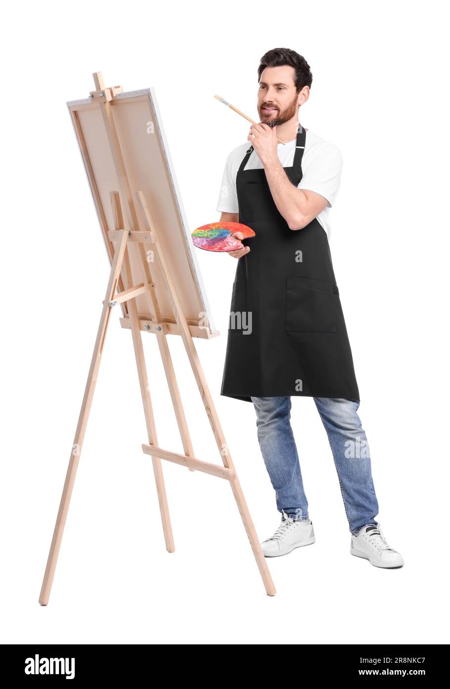Artiste avec pinceau sur fond blanc. Utilisation du chevalet pour tenir la toile Banque D'Images