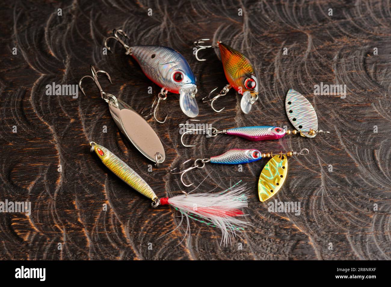 Jeu de leurres en métal et en plastique pour la pêche sur une surface en chêne foncé Banque D'Images
