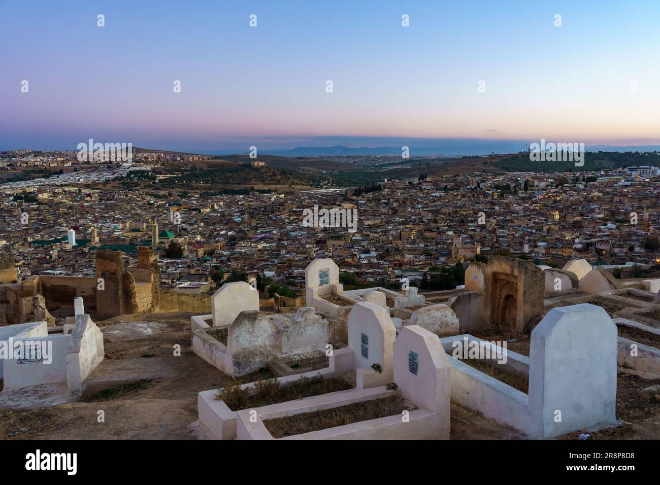 Maroc. Fez. Vue sur la colline au-dessus de la vieille médina à Fès avec les tombeaux au crépuscule. Au centre de la mosquée Karaouiyine Banque D'Images
