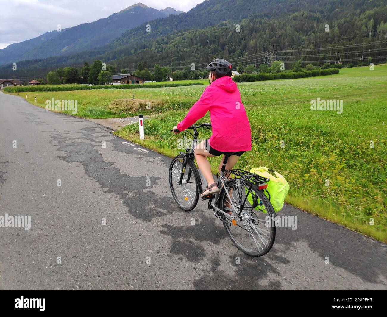 Une cycliste féminine portant un casque se déplace sur la piste cyclable longue distance de Gailradweg dans la région de Gailtal en Carinthie, en Autriche. Banque D'Images