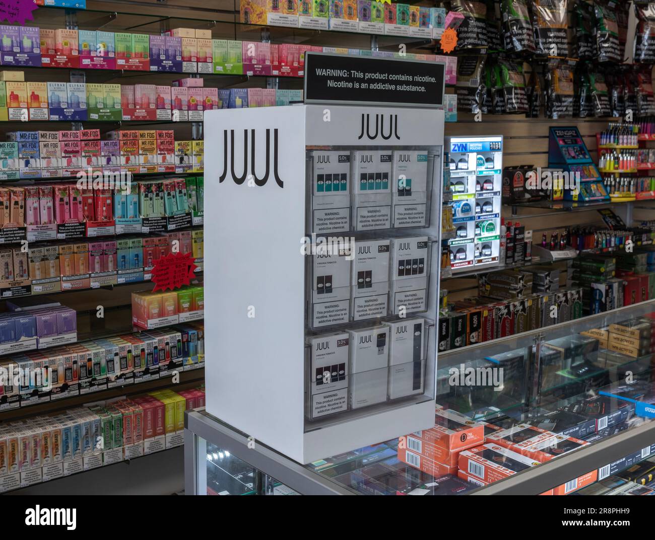 Juul vape pod cigarette électronique appareil avec un paquet de cigarettes  de Marlboro et une cigarette à l'extérieur sur une table isolée, texturé  Blanc Photo Stock