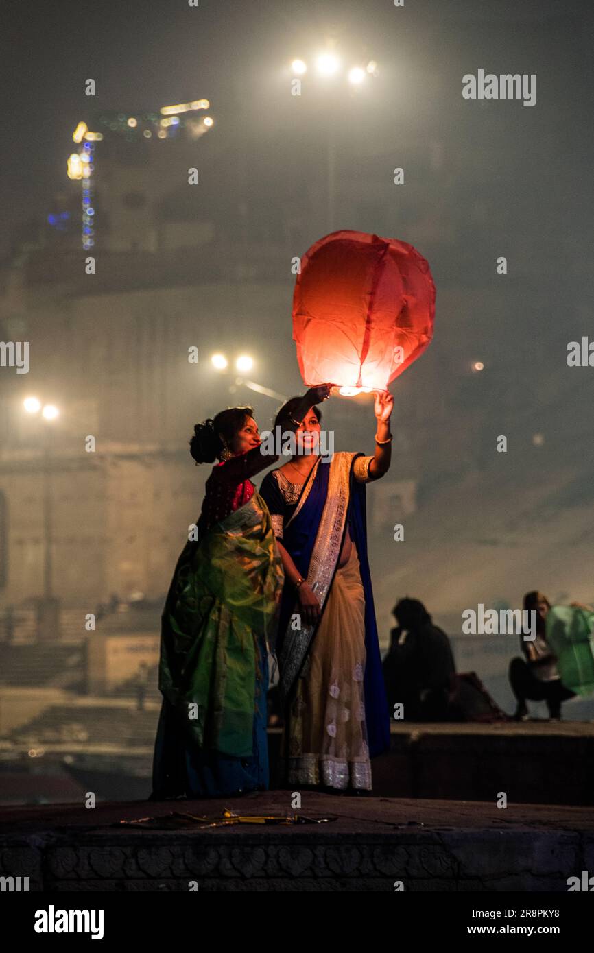 Les femmes lancent une lanterne en papier sur les ghats de Varanasi, Inde Banque D'Images