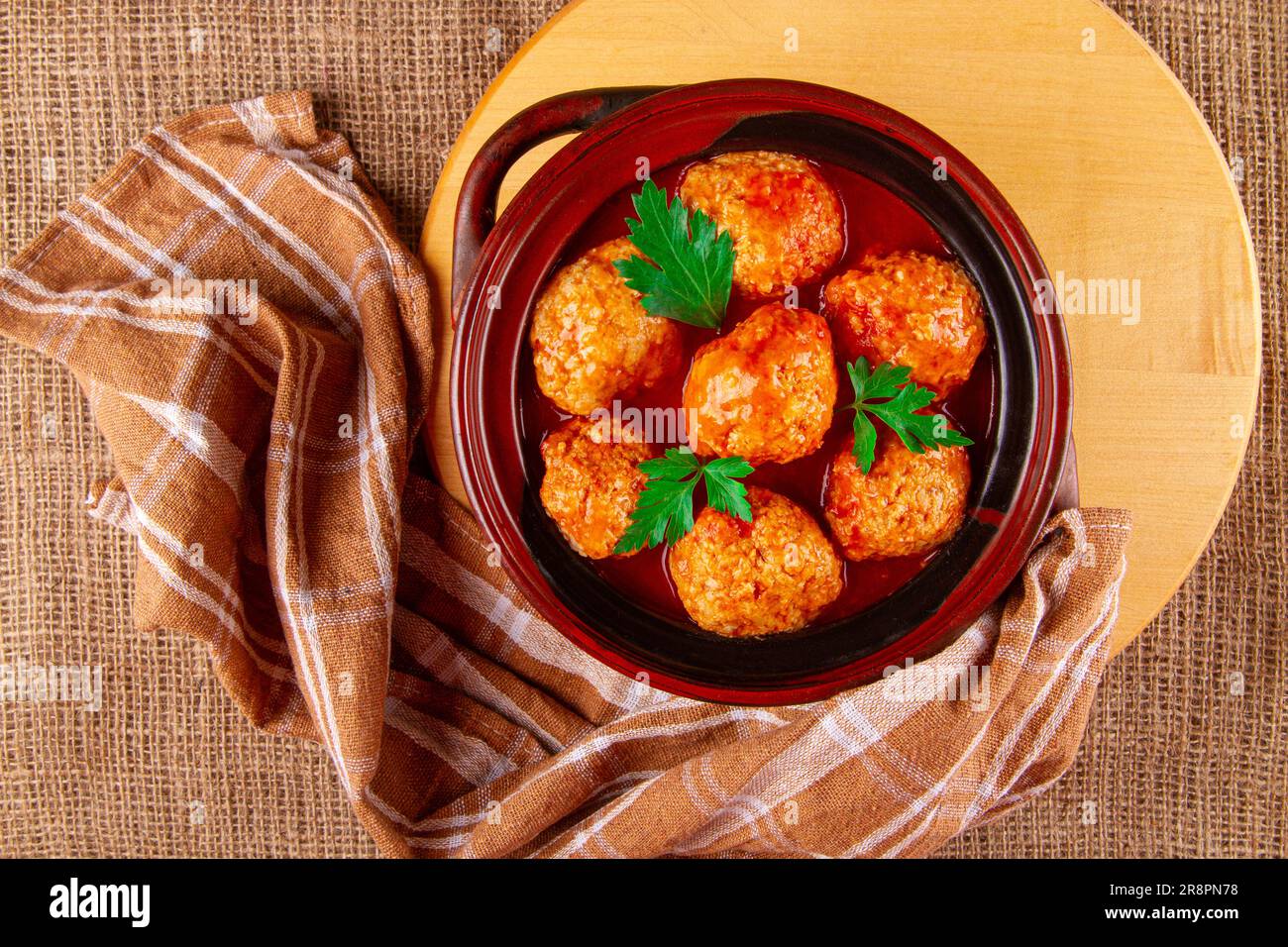 Moule en argile avec boulettes de viande de kottbullar fraîchement préparées dans une sauce rouge Banque D'Images