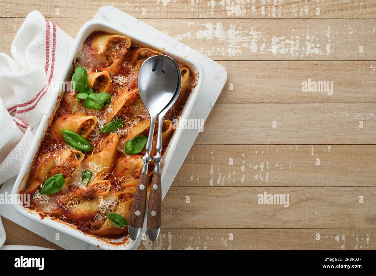Cannelloni ou conchiglioni. Pâtes farcies cuites au four avec sauce à la viande bolognaise, tomates, basilic sur table rustique en bois. Bolo italien traditionnel Banque D'Images