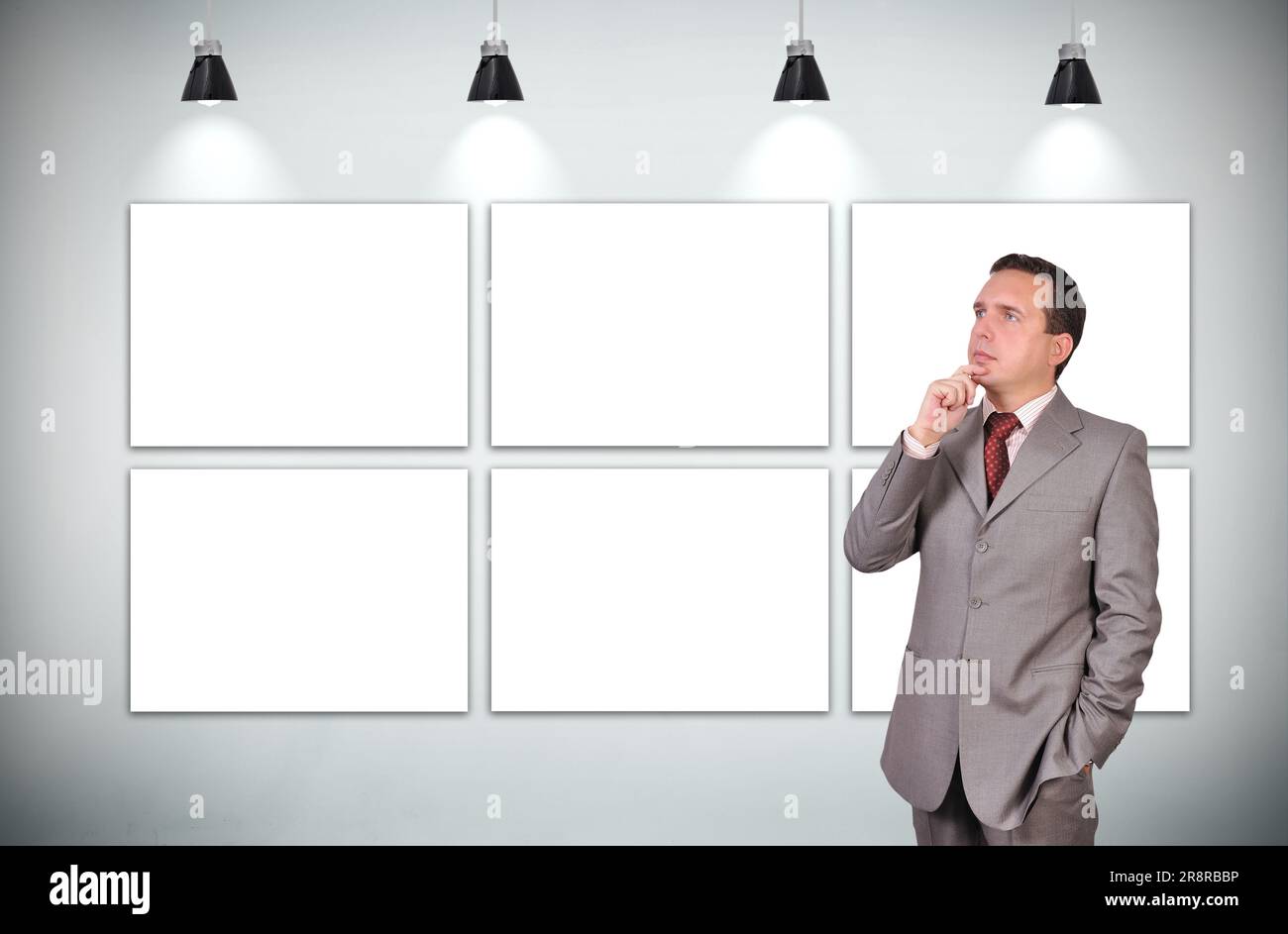 homme d'affaires pensant debout dans la galerie avec six cadre blanc Banque D'Images