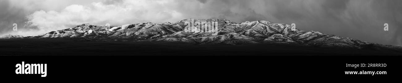 Une vue aérienne stupéfiante d'une montagne, enveloppée dans un manteau de nuages dans une photo spectaculaire noir et blanc Banque D'Images