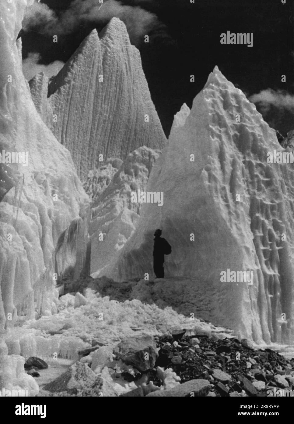 Daily Mail abominable Snowman Expedition -- Stanley Jeeves nain par des pinacles de glace sur l'Everest icefall. Sur 5 mai, tous les membres disponibles de l'expédition du Daily Mail ont fait un anniversaire « symbolique » en montant l'icefall de l'Everest, atteignant un point à mi-chemin environ jusqu'au camp britannique 11. 9 juin 1954. Banque D'Images