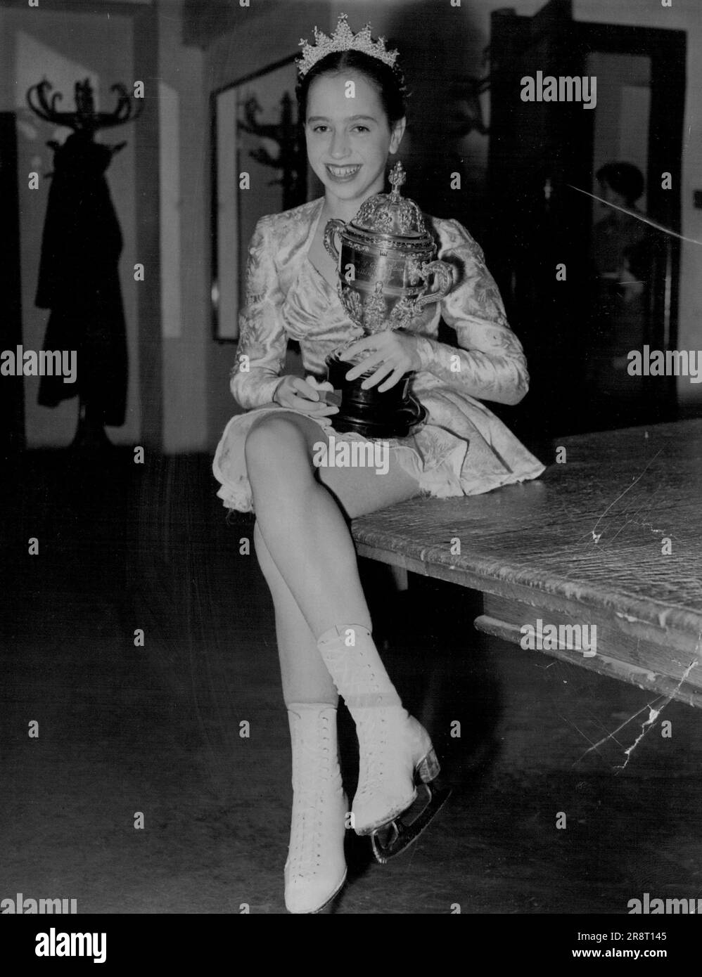 La photo ci-jointe peut être reimprimée dans votre journal moyennant des frais de 1 à 1s £. sterling, payable à Central Press Limited, 80, Fleet Street, London, E.C. 4. Yvonne Sugden, tenant la coupe qu'elle a gagnée pour le championnat britannique de patinage amateur sur glace. Yvonne Sugden remporte le championnat de patinage - Yvonne Sugden, une écolière de Kensington de 14 ans, se toaste de la coupe qu'elle a gagnée, après être devenue la championne du patinage amateur des nouvelles femmes de Grande-Bretagne à Streatham Ice Rink, ce soir. Elle a remporté le titre après l'une des finales les plus spectaculaires de l'histoire de la compétition. 12 avril 1953. (Photo… Banque D'Images