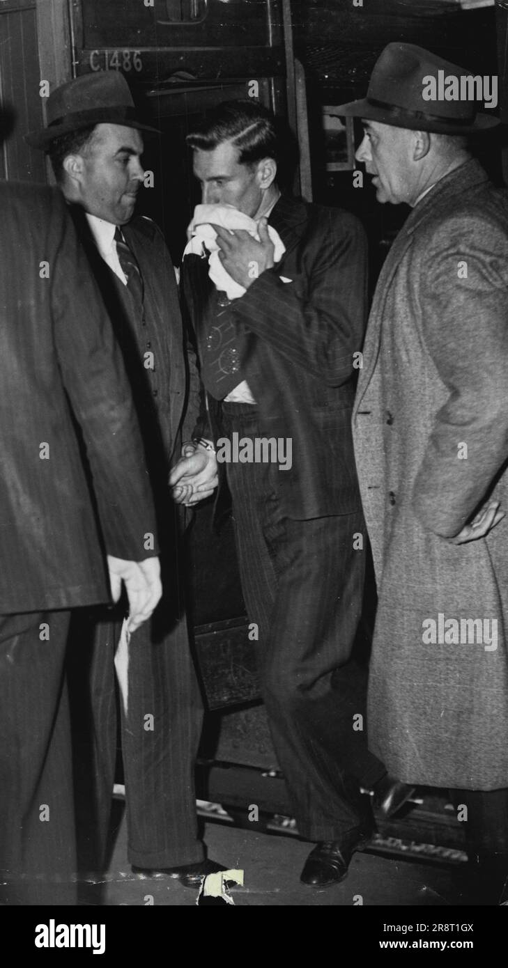 Keith Hope, compagnon de la criminalité de Grant, arrive au Centre ***** après avoir marché dans la scène poste de police et se donnant ***** . Le compagnon de meurtres arrive à la gare centrale de Scene. DET. Strachan menotté à l'accusé Keith Hope ou Beckett l'autre Det. Sgt Hargraves. Ces deux officiers ont escorté l'espoir de la scène. Et sont ici vus le conduisant du train. Hop a caché son visage des caméras et de la foule ***** . 15 août 1946. (Photo de Gordon Herbert Short/Fairfax Media). Banque D'Images