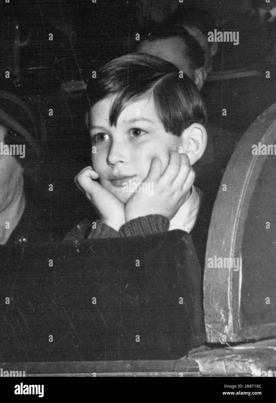 Au Cirque - le prince Michael, fils de la duchesse de Kent - à Olympia le samedi 6th janvier - passe par les changements d'expression que vous pouvez toujours attendre quand un garçon voit des clowns tomber dans l'anneau de cirque. Tout d'abord, il est assis dans la contemplation. Les clowns sont encore tranquilles. 0, cher ! Consternation comme un jester à nez rouge, avec un ballon sur un bâton, avance derrière un autre. Alors, attendez-vous à une pure exultation car, d'un seul coup de son ballon, le nez rouge prive l'imprudent de son chapeau. 8 janvier 1951. Banque D'Images