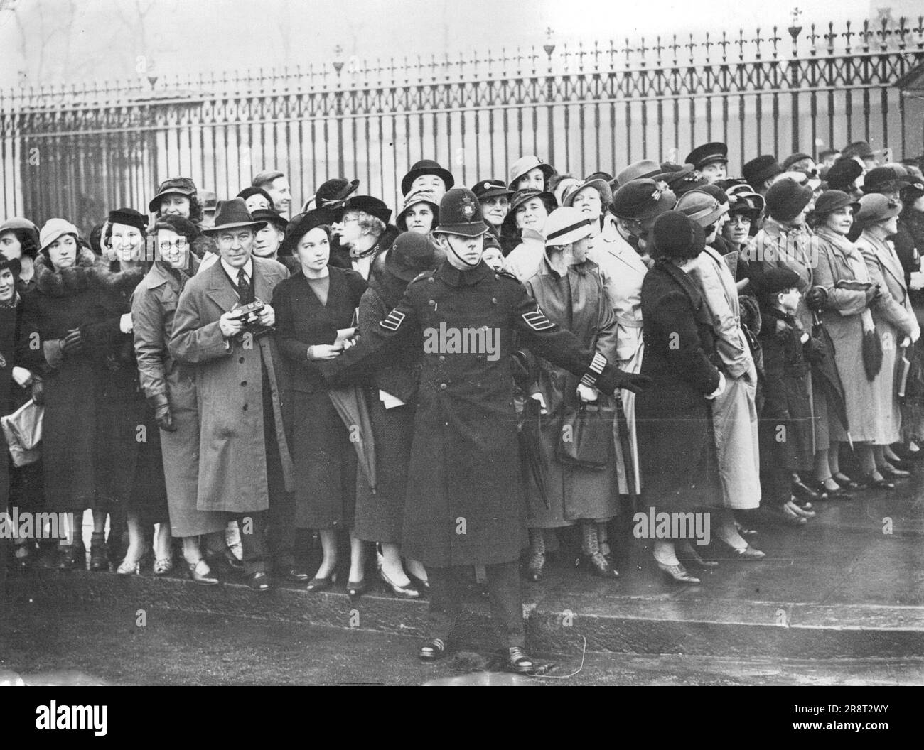 Baptême royal d'aujourd'hui - une partie de la foule attend devant le palais de Buckingham pour apercevoir les arrivées de la cérémonie de baptême. Le fils naissant du duc et de la duchesse de Kent est baptisé aujourd'hui le 20 novembre par l'archevêque de Canterbury dans la chapelle de Buckingham Palace. On lui donne les noms Edward George Nicholas Patrick. 20 novembre 1935. (Photo par photo de presse associée). Banque D'Images