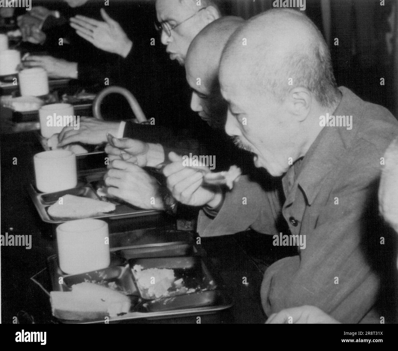 Tojo déjeuners entre les sessions de la Cour - Hideki Tojo, premier ministre de la guerre de Jap (premier plan droit) mange de l'un des plateaux de mess familiers à tous les SIG américains pendant un séjour 3 mai dans les procédures du Tribunal des crimes de guerre de Tokyo contre Tojo et 27 autres top Jap. les chefs de guerre. À côté de Tojo se trouve Shunroku Hata et au-delà de Hata Namoru Shigemitsu. 09 mai 1946. (Photo par AP Wirephoto). Banque D'Images