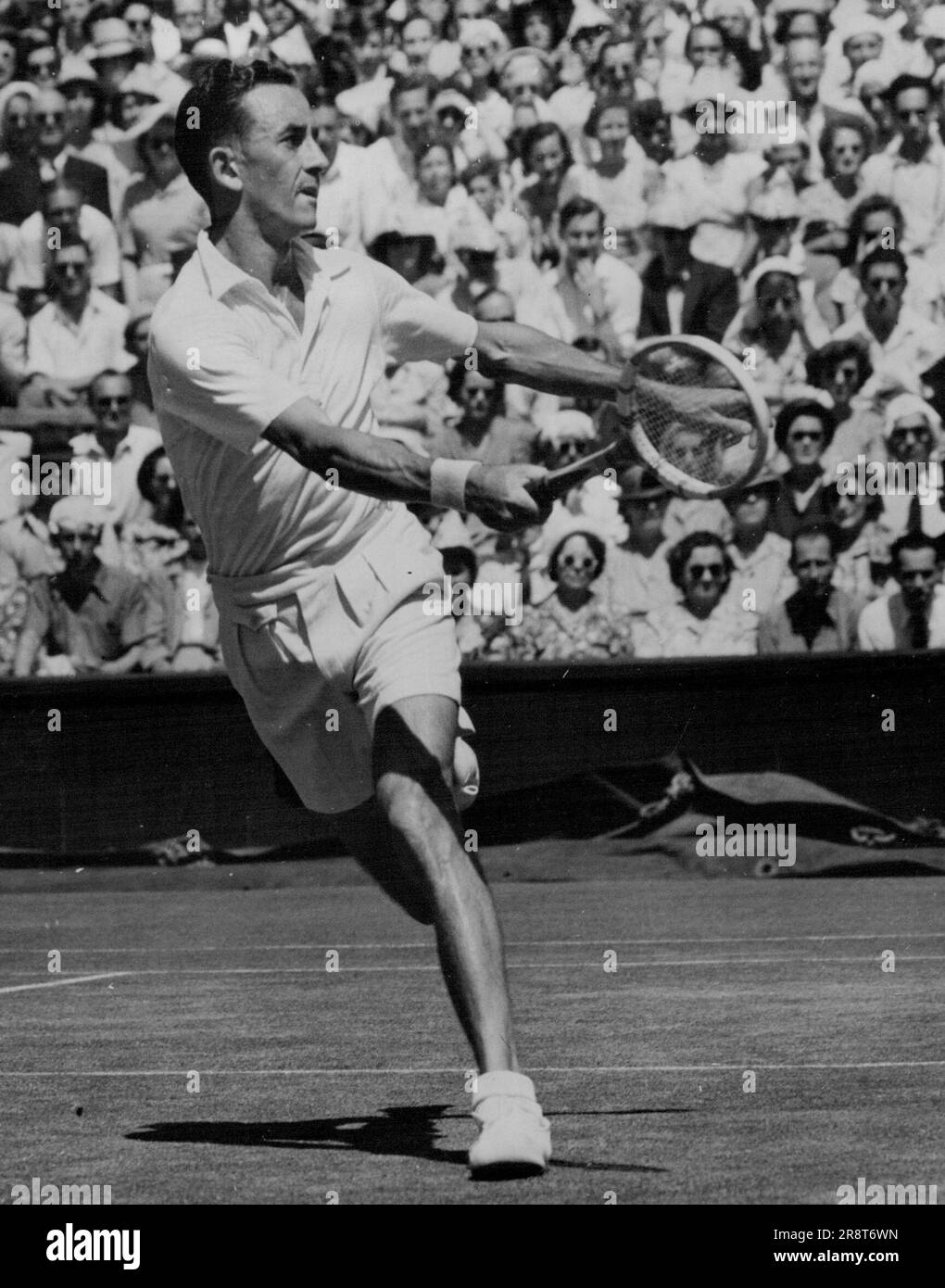 Le champion sud-africain atteint - Eric Sturgess (Afrique du Sud) en jeu contre Frank Parker (Etats-Unis), qu'il a battu dans le quart de finale du championnat masculin de célibataires à Wimbledon aujourd'hui (lundi). Eric Sturgess, champion sud-africain, s'est qualifié pour la demi-finale des championnats de tennis sur gazon pour hommes à Wimbledon (Londres) aujourd'hui (lundi) en battant Frank Parker (États-Unis) 3-6, 6-4, 3-6, 6-1, 6-3. Parker, qui a remporté le championnat de France depuis deux ans, a été grandement émancipé. 27 juin 1949. (Photo de Reuterphoto). Banque D'Images
