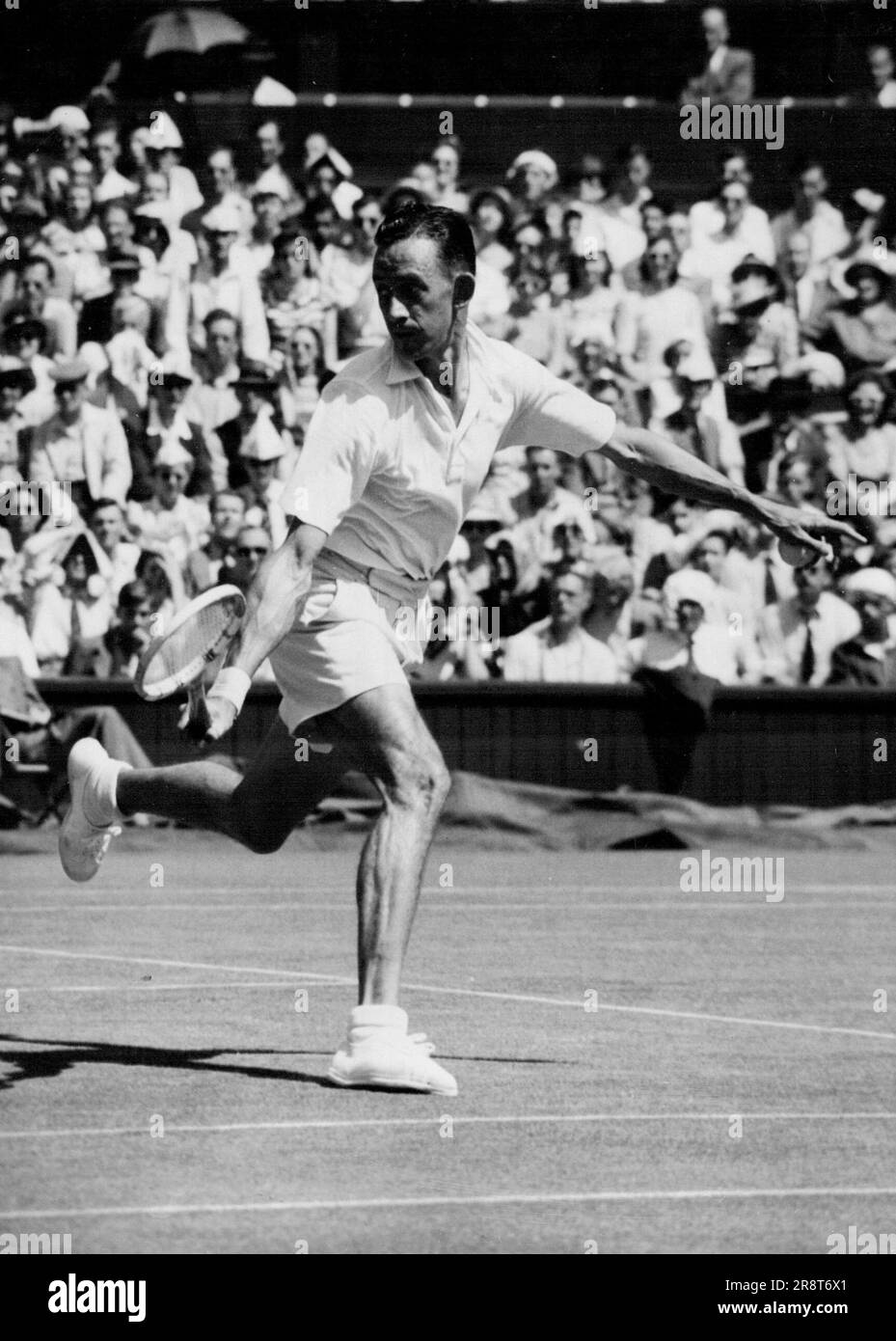 Sturgess jusqu'à semi final - Sturtgess fait un retour à la main pendant le jeu. Dans une bataille sinistre, s'est battu sur le terrain de centre-ville de Wimdledon, Londres Eric Sturgess, d'Afrique du Sud, a frappé l'américain Frank Parker hors des singles hommes ainsi après-midi 27 juin. Le début de la fin de la partie dans la quatrième série. Parker était alors à la tête par 2 ensembles à 1, mais l'Afrique du Sud a rompu par son service pour diriger 3-1, puis par pleine de confiance pour prendre l'ensemble 6-1, nivelant le jeu à 2 ensembles tous. Dans le jeu final, Sturgess a gagné confortablement. 6-3. Score final, Sturgess d'abord; … Banque D'Images