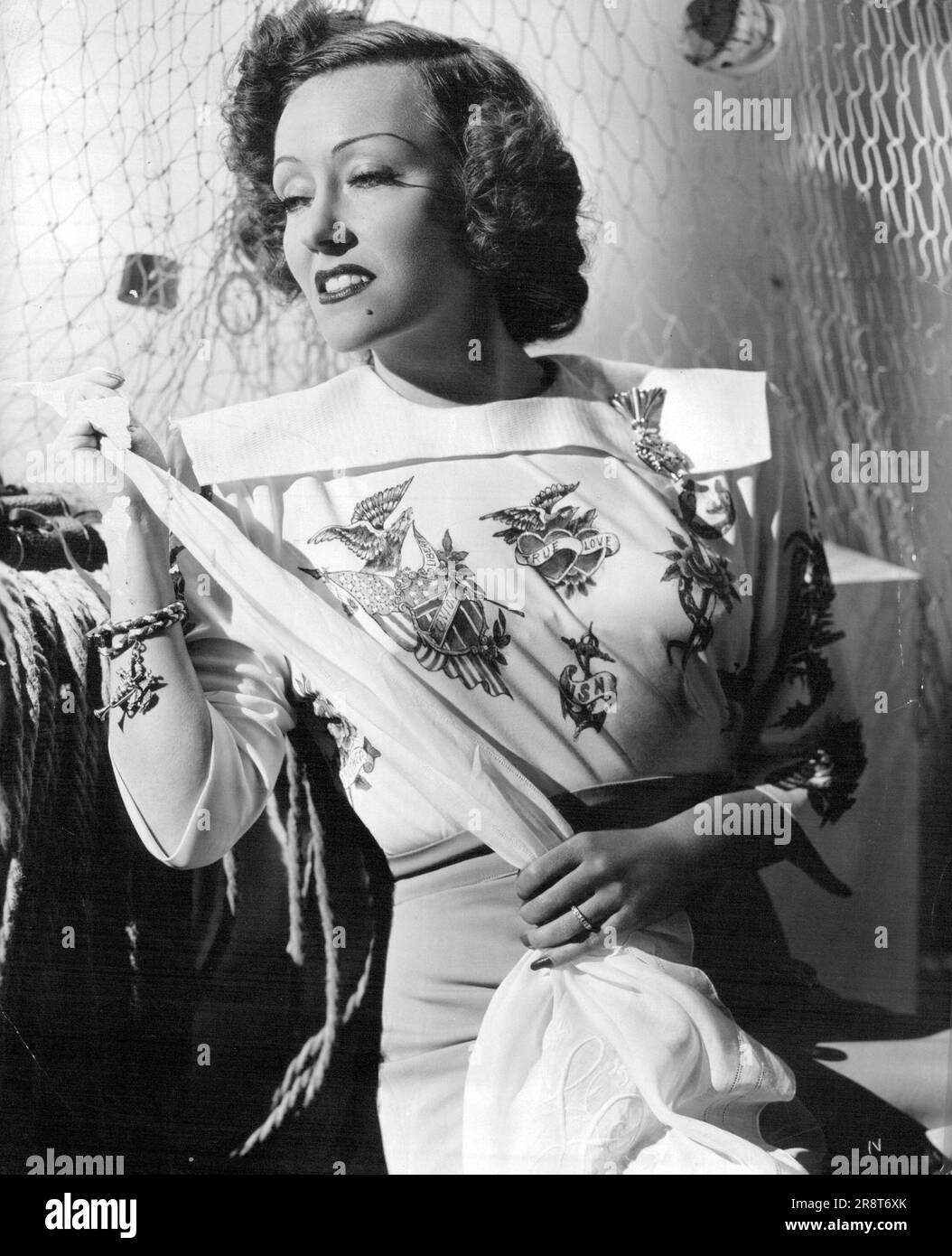 Tatouage pour la mode - la plupart des effets de roman de la journée a été travaillé dans ce chemisier tatoué pour Gloria Swanson, de retour à l'écran dans RKO radio 'le Père prend Une femme,' avec Adolphe Menjou. Le chemisier a été conçu par le styliste Renee Hubert, qui a appelé le professeur James Fraser de Los Angeles à travailler dans les modèles standard de tatouage, 30 d'entre eux. 18 septembre 1953. Banque D'Images