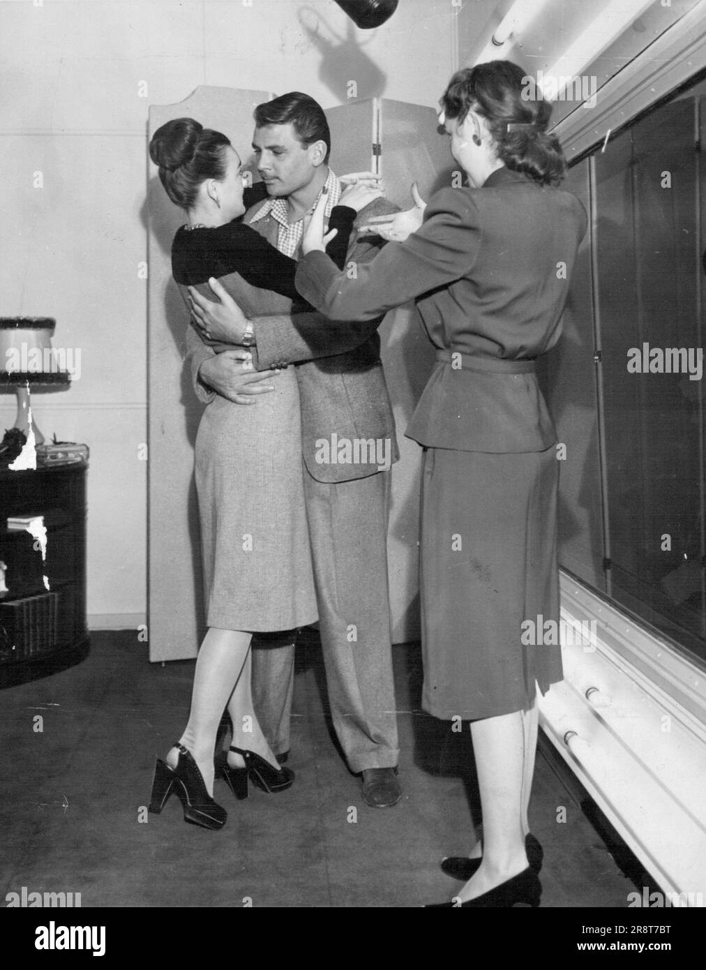 Entraîneur de talent de film l'entraîneur de drame Charlotte Clary donne instruction à TAD et Sally, Newcomers de filmer en action . Comment être au cours de leur scène d'amour. Cette salle est appelée « Fich Bowl » par les joueurs car elle est si bien agencée que les officiels du studio peuvent voir les artistes à travers un rideau de verre (à droite) sans être observée. Entraîneur de cinéma. Charlotte Clary, entraîneure de théâtre. instruit deux nouveaux scénarios dans l'art de l'amour-faire. La salle est appelée « Fish Bowl » par les joueurs, car elle est si disposée que les officiels du studio peuvent voir les artistes à travers un rideau de verre (à droite), sans être observée. D… Banque D'Images