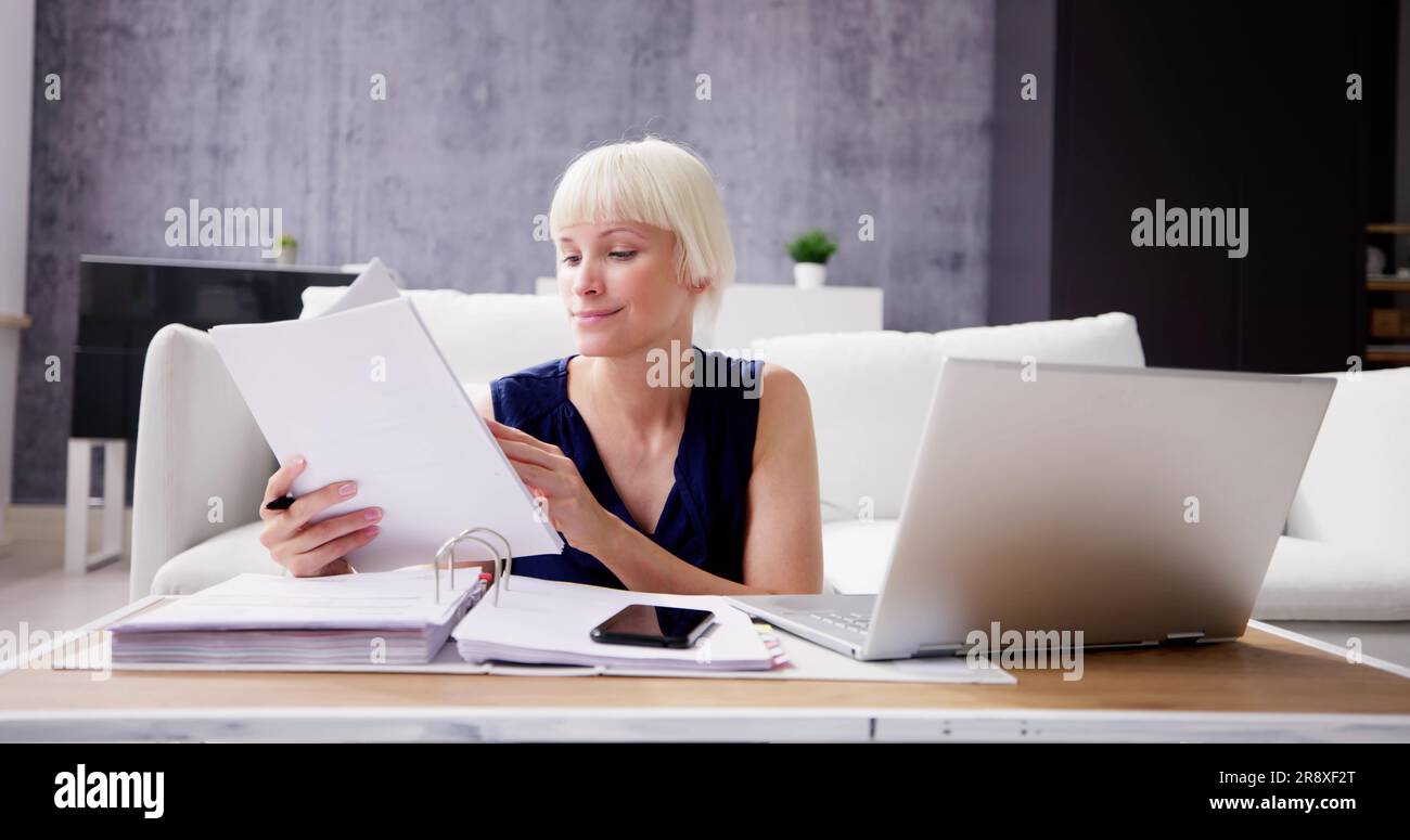 Jeune femme assise sur un canapé dans sa chambre Projets de calcul Banque D'Images