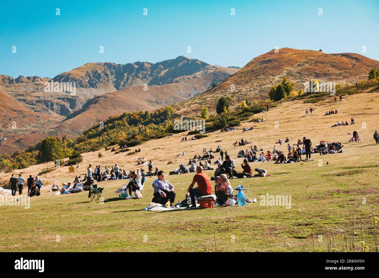 Les gens se détendent sur les pentes herbeuses de Prevalla Field un après-midi ensoleillé de week-end d'été à Prevalla, une ville de montagne au Kosovo Banque D'Images