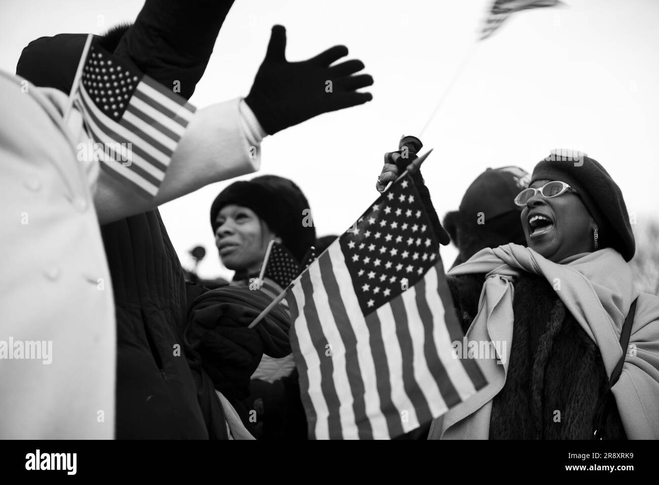 Un groupe d'Afro-Américains se réjouit des drapeaux américains alors que Barack Obama prend ses fonctions lors de l'investiture présidentielle de 2009. Banque D'Images