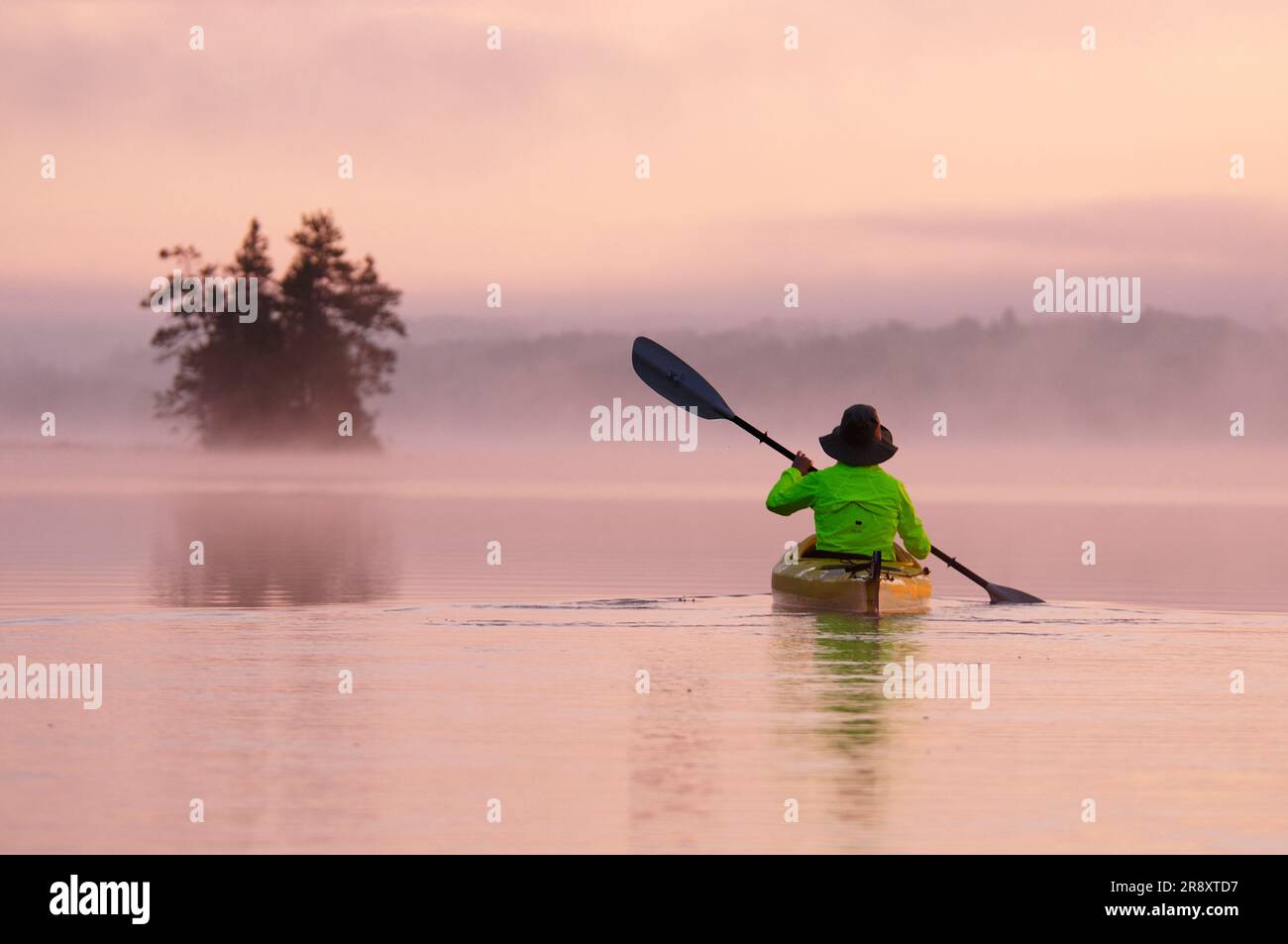 Une femme faisant du kayak à Birch Lake, dans la région de Boundary Waters Wilderness Canoe Area, Minnesota, États-Unis. Banque D'Images