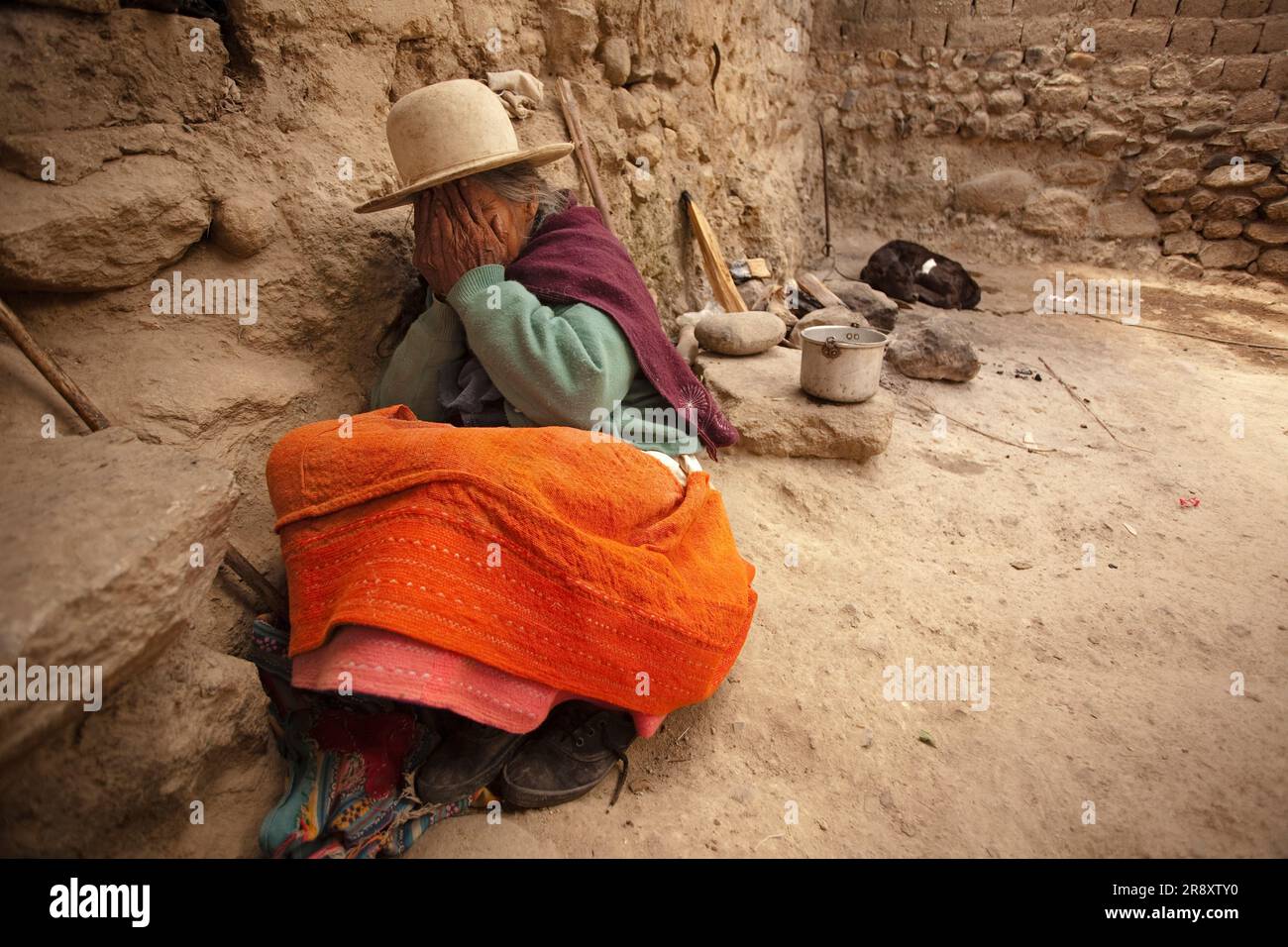 La vieille femme péruvienne se cache de la caméra tout en étant assise dans le sol. Huaraz, Pérou. Banque D'Images