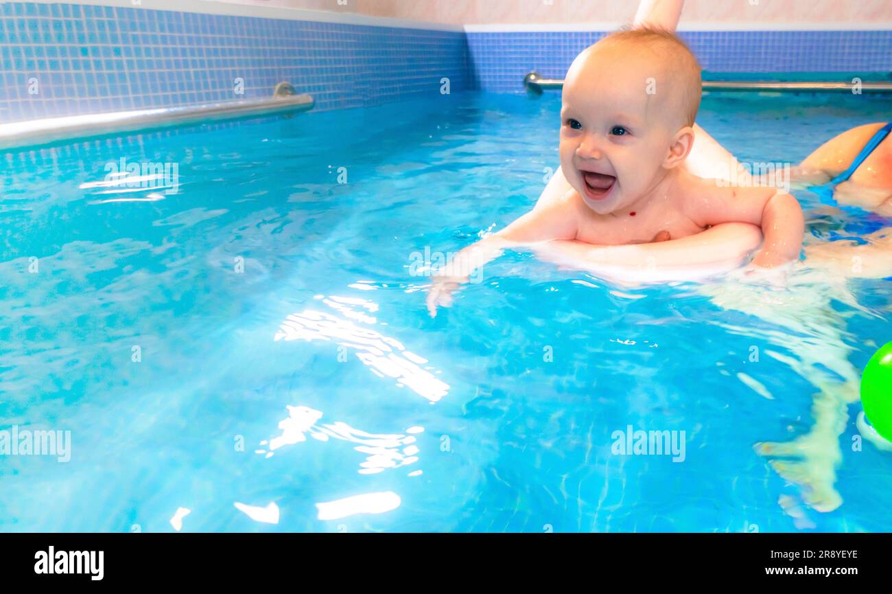Adorable petite fille appréciant nager dans une piscine avec sa mère cours de développement