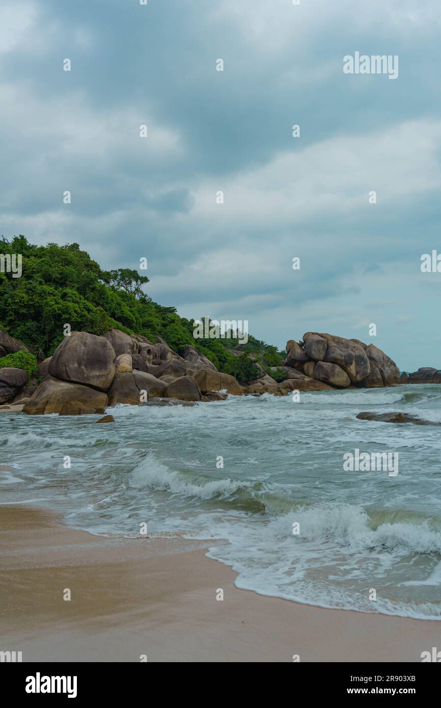 Vagues dansant au milieu de Rocky Shores, sous un ciel lunatique à Crystal Bay Beach, Koh Samui, Thaïlande Banque D'Images