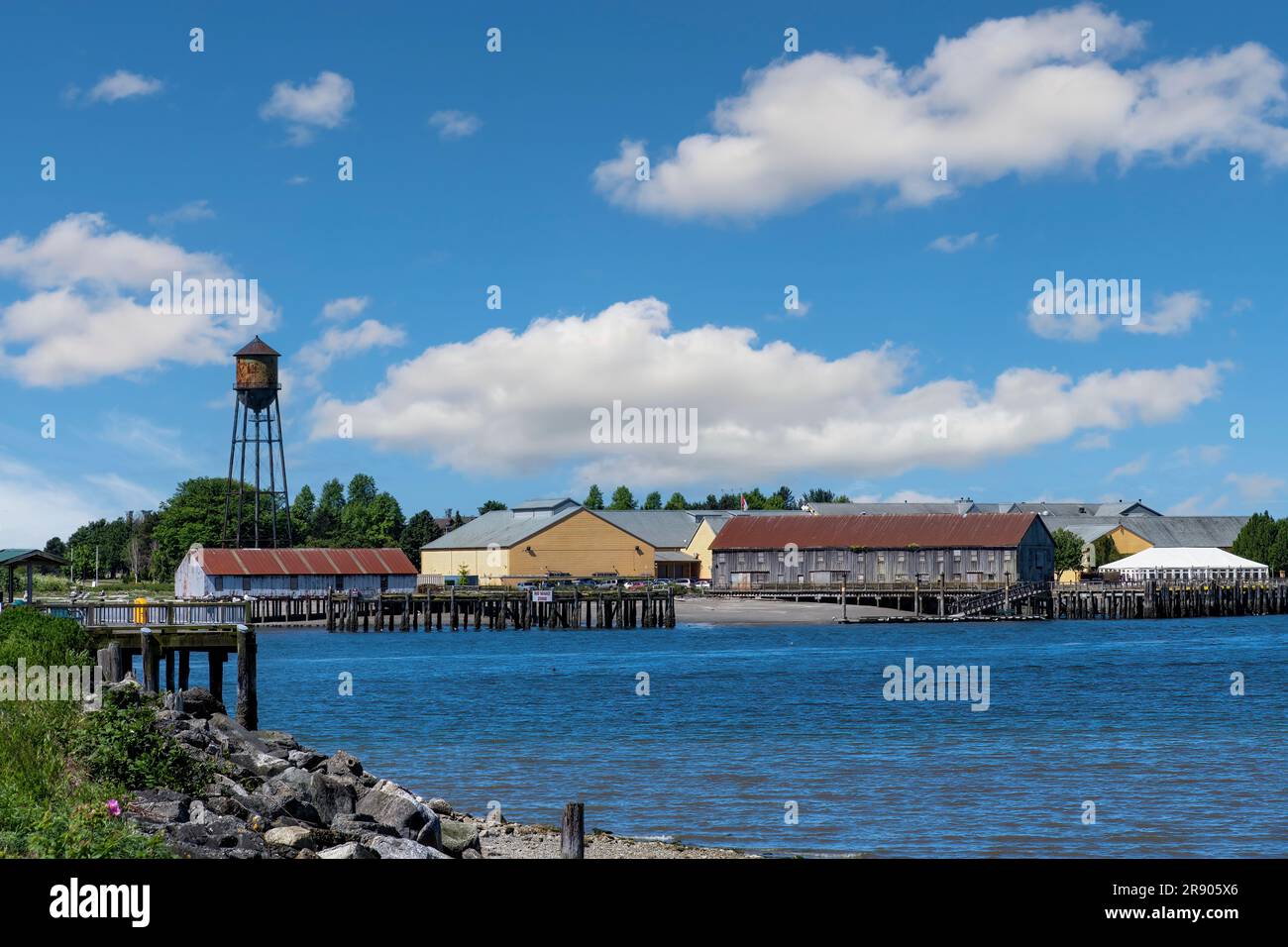 Blain, WA, USA-juillet 2022 ; vue panoramique sur l'eau de la baie de Semiahmoo vers les bâtiments de la station balnéaire de Semiahmoo avec la légendaire tour d'eau rouillée, construite à giv Banque D'Images