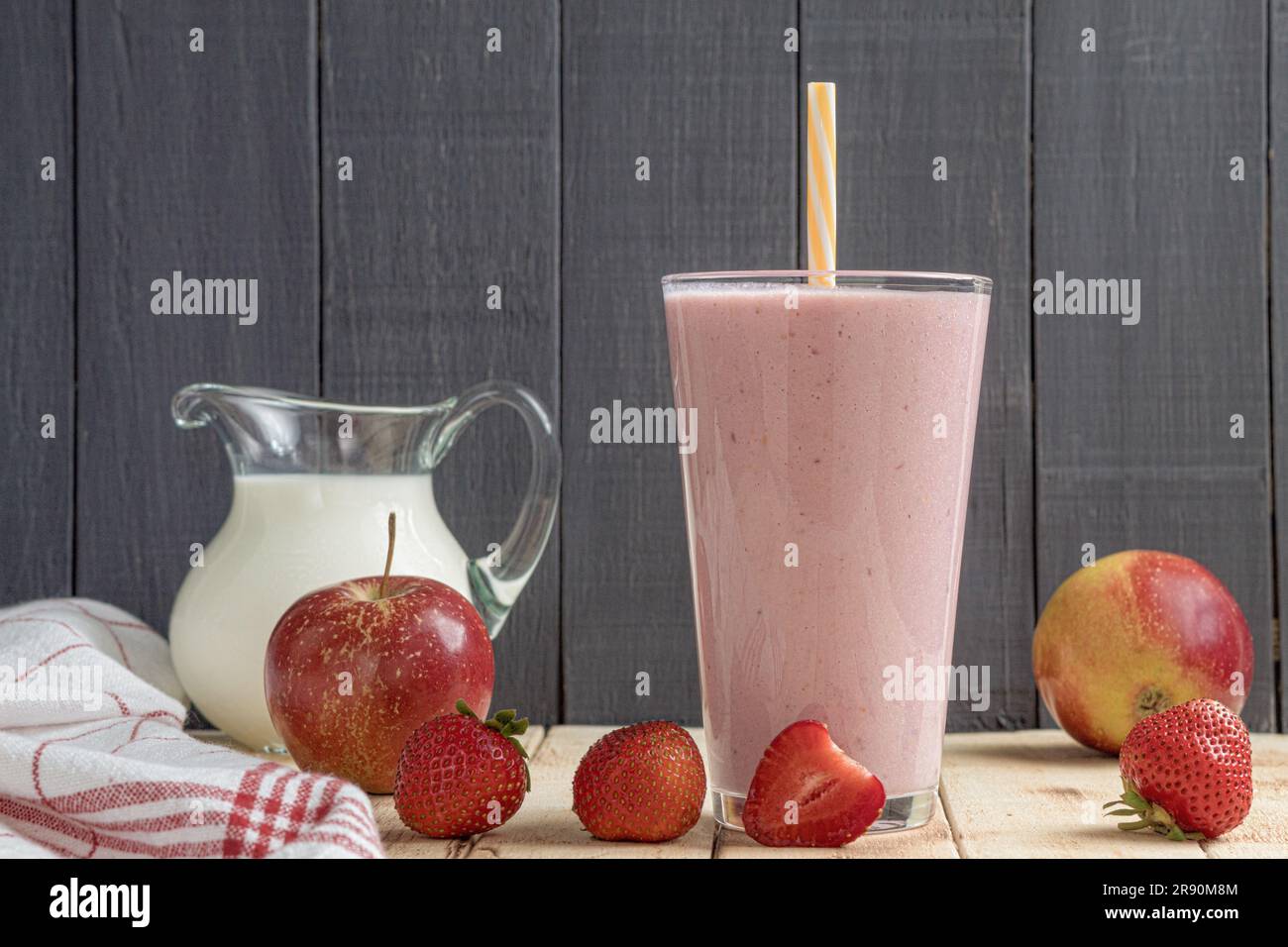 Milk-shake frais avec fraises. Un verre de milkshake frais de fraise, de purée et de fraises fraîches sur fond de bois. Des aliments et des boissons sains Banque D'Images