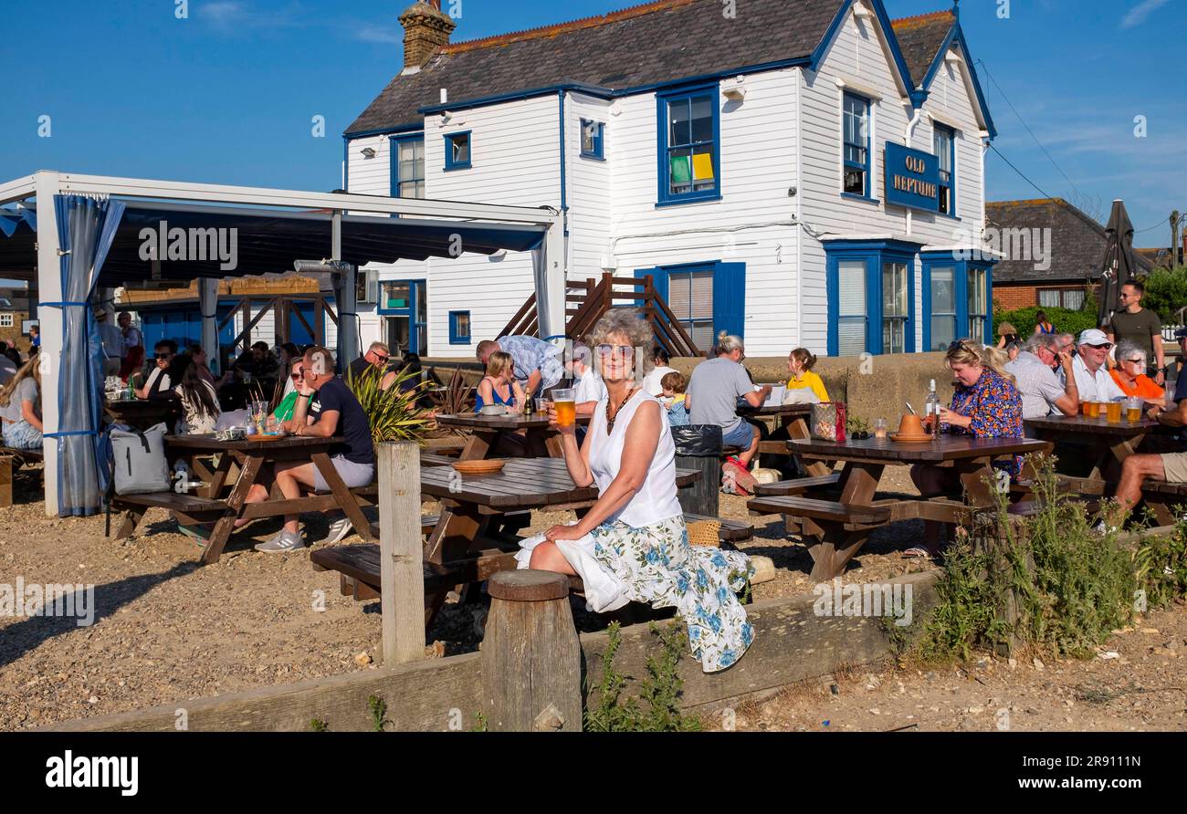 Whitstable Nord Kent , Angleterre UK - Tourisme féminin aime une bière à l'extérieur du célèbre pub Old Neptune sur le front de mer en plein soleil Banque D'Images