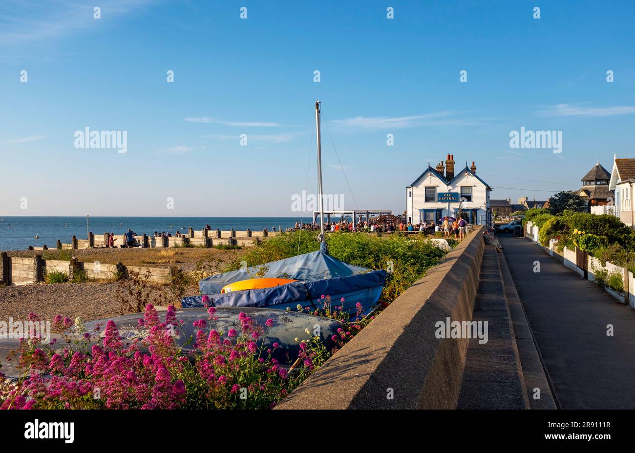 Whitstable North Kent , Angleterre Royaume-Uni - les visiteurs qui apprécient un verre devant le célèbre pub Old Neptune sur le front de mer sous le soleil d'été Banque D'Images
