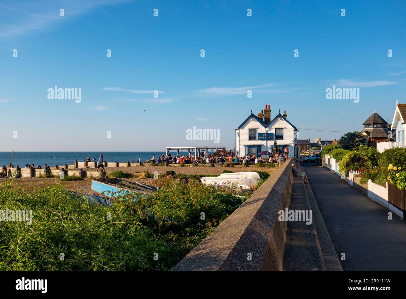 Whitstable North Kent , Angleterre Royaume-Uni - les visiteurs qui apprécient un verre devant le célèbre pub Old Neptune sur le front de mer sous le soleil d'été Banque D'Images