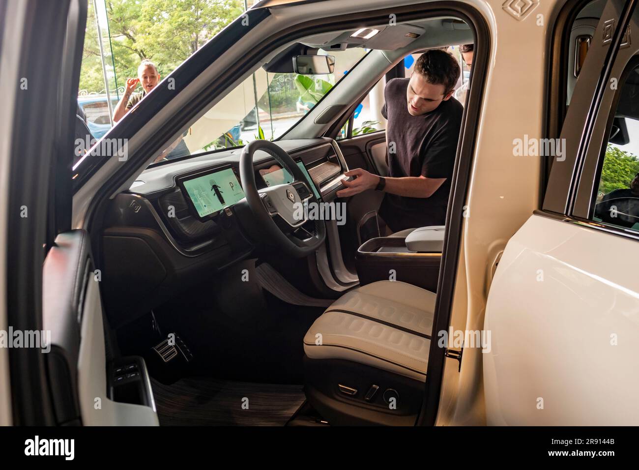 Les passionnés d'automobile assistent vendredi à l'inauguration d'une salle d'exposition Rivian Spaces dans le quartier de Meatpacking à New York, 16 juin 2023. Rivier s'est joint à d'autres fabricants de véhicules électriques de luxe Tesla, Genesis et lucide dans le quartier de Meatpacking. (© Richard B. Levine) Banque D'Images